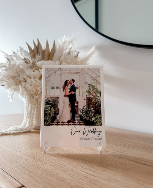 Close up wedding Anniversary photo plaque for valentines day. Sitting on wooden bench with clear acrylic display stand.