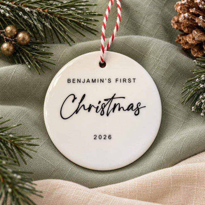 Back of the ceramic bauble reading Benjamin's First Christmas 2026 in black script and capitals