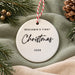Back of the ceramic bauble reading Benjamin's First Christmas 2026 in black script and capitals