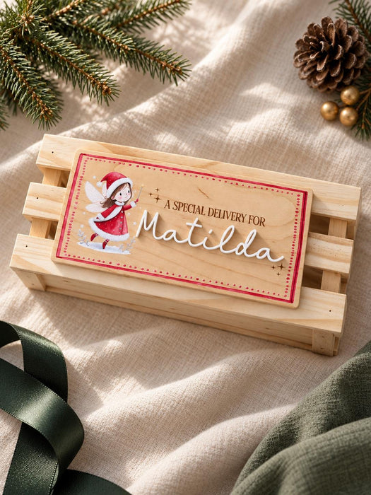 Santa crate sign in natural wood with an illustrated Christmas elf and Matilda in white acrylic, on a wooden crate