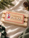 Santa crate sign in natural wood with an illustrated Christmas elf and Matilda in white acrylic, on a wooden crate