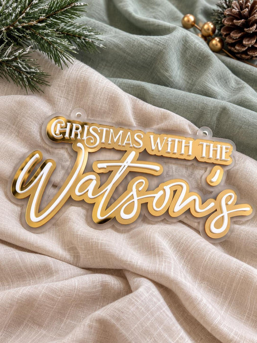 Close up of the gold mirror and white script lettering on the layered family name sign