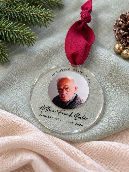 Memorial Christmas ornament in clear acrylic with a colour photo of Arthur Frank Babic and his dates, hanging from a deep red ribbon