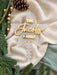Frosted acrylic family name star with its notched stick, styled with pine branches and gold baubles