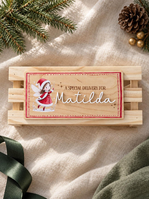 Wooden elf name plaque reading A special delivery for Matilda, shown straight on against a wooden crate