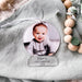 A photo of a young child printed onto a Christmas ornament. Their is writing etched into the decoration stating Xavier's First Christmas 2022